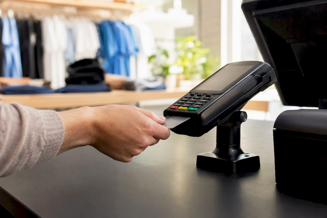 Hand inserting card into POS terminal